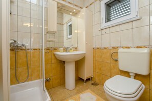 A bathroom with a bathtub, a sink, and a toilet. - Apartment and Rooms Mate (Bol)