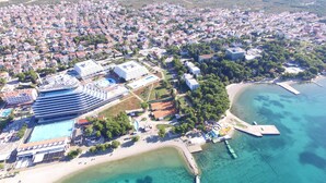 An aerial view of a coastal resort with a large hotel, swimming pools, and a beach area. - Apartments Sweet Escape (Vodice)