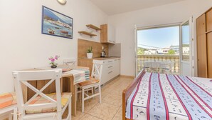 A small, bright room with a kitchenette, a dining area, and a balcony with a view. - Apartments Sweet Escape (Vodice)