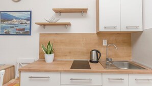 A modern kitchen with wooden countertops, a stainless steel sink, and white cabinets. - Apartments Sweet Escape (Vodice)