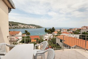 Un balcón con vista al mar y a un pueblo.