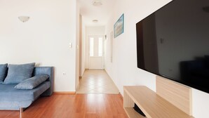 Una sala de estar moderna con un sofá, un televisor y un banco de madera.