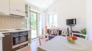 Una cucina moderna con forno integrato e zona pranzo con tavolo apparecchiato per due persone.