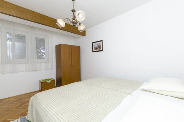 Une chambre à coucher avec un lit, une armoire en bois et un lustre.