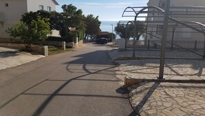 A residential street with houses, a car, and a staircase leading to a building. - Apartments Caric (Ivan Dolac)