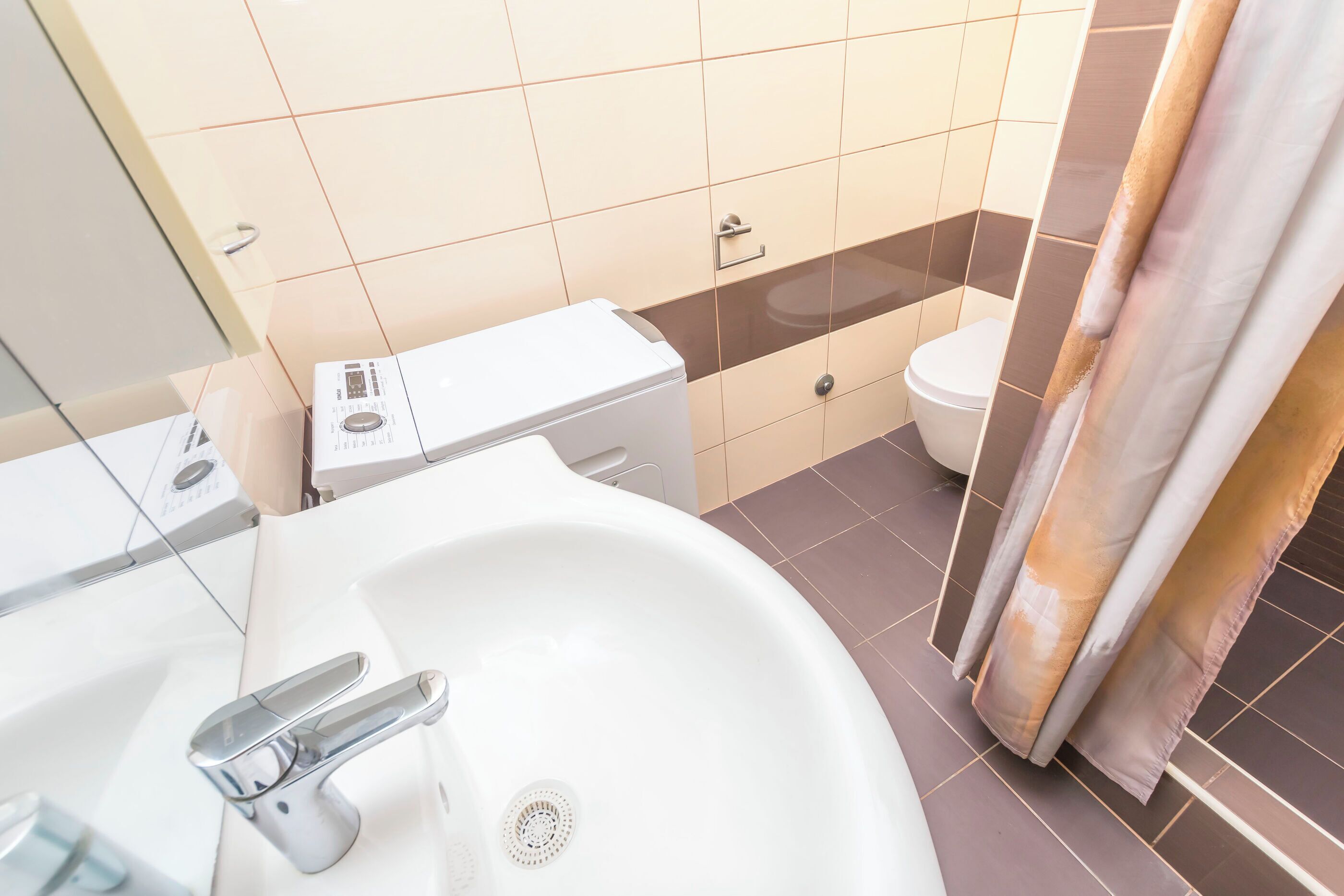 A bathroom with a white sink, a toilet, and a shower curtain.