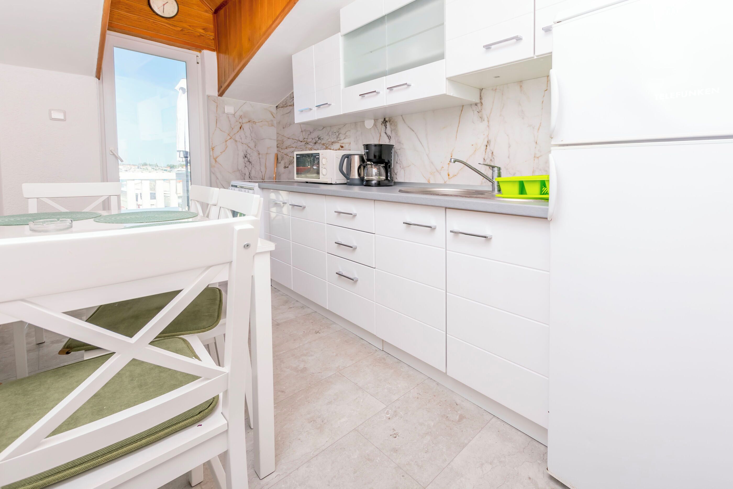 A modern kitchen with white cabinets, a coffee maker, and a microwave.