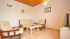 A living room with a sofa set, a coffee table, a television, and a cabinet. - Apartment Jakov (Okrug Donji)