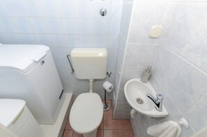 Ein kleines Badezimmer mit Toilette, Waschbecken und Handtuchhalter.