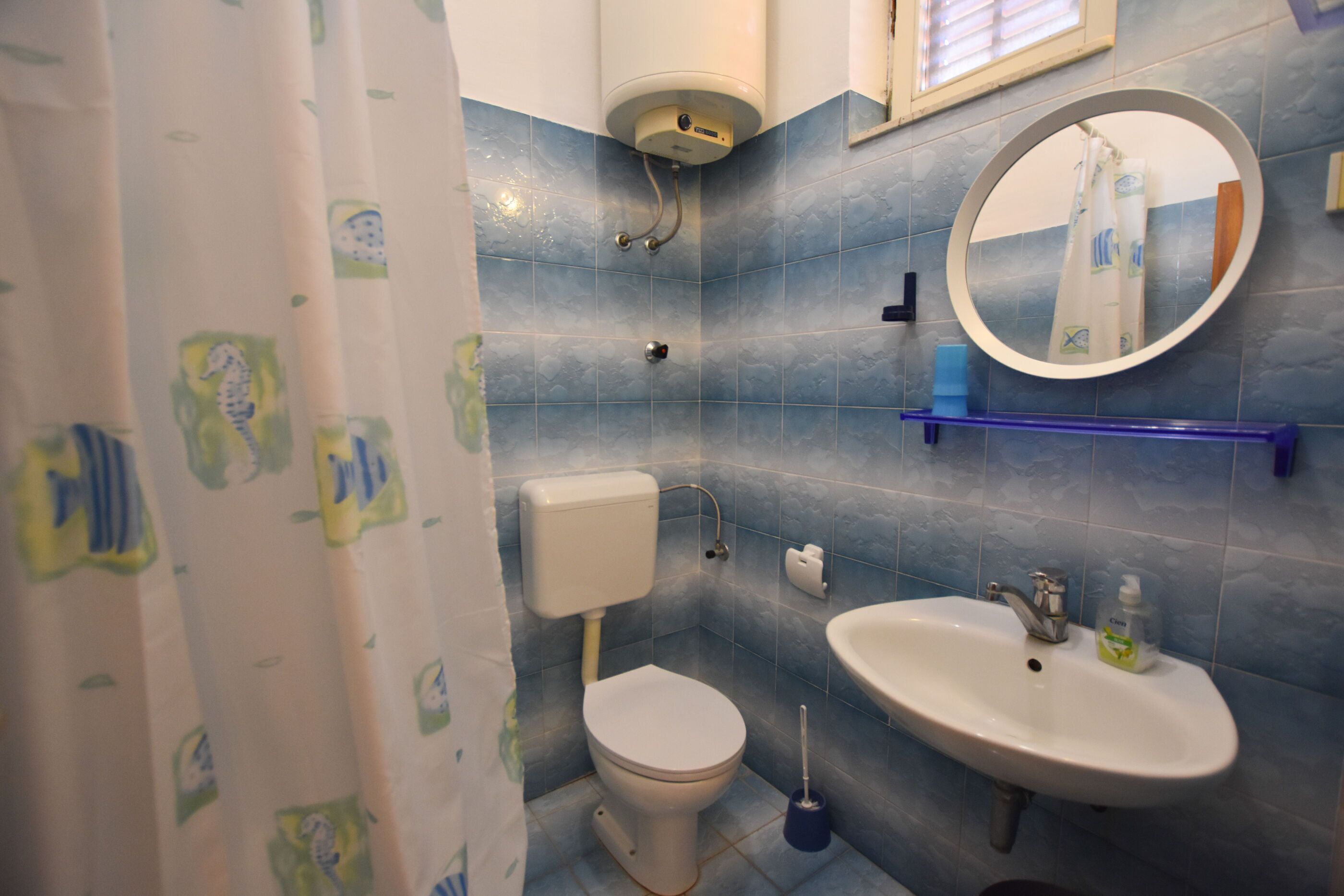 Un baño con inodoro, lavamanos y ducha.