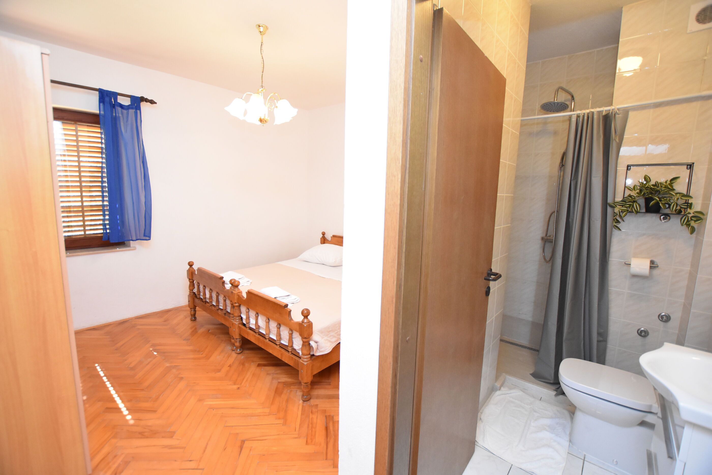 Una camera da letto con un letto di legno e un bagno con doccia e servizi igienici.