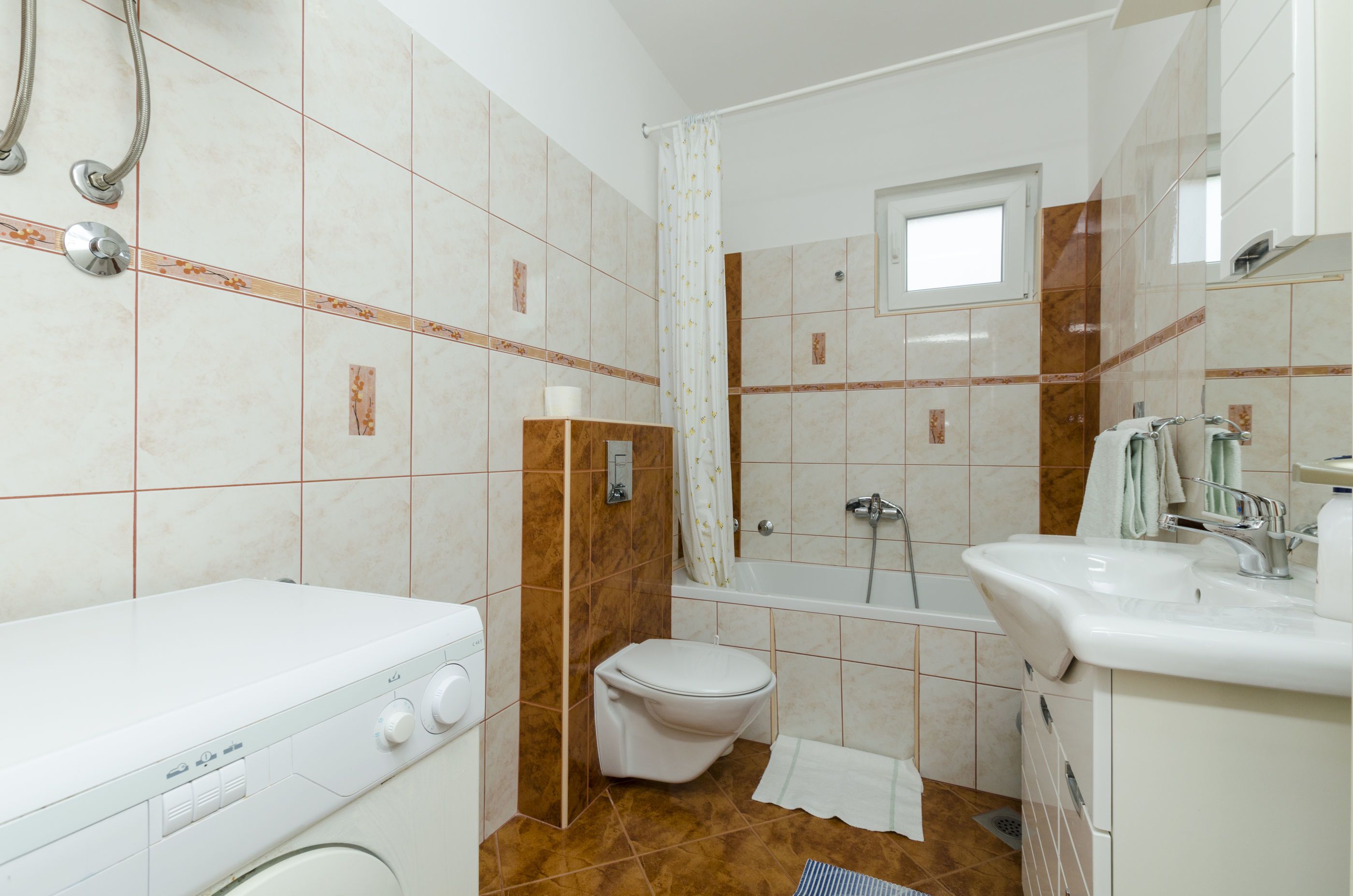 A bathroom with a white toilet, a bathtub, and a sink.
