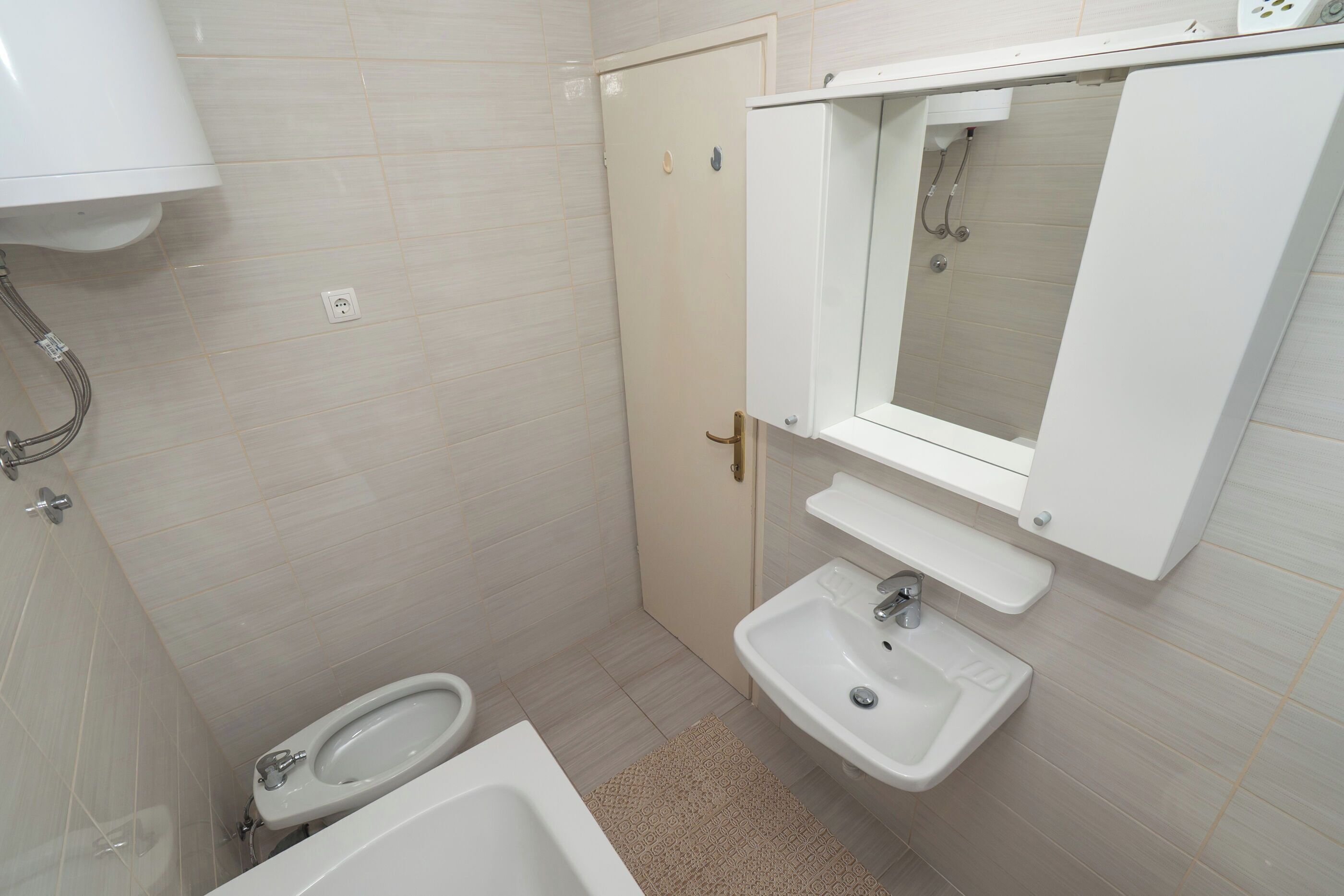 Een kleine badkamer met toilet, wastafel en douche.