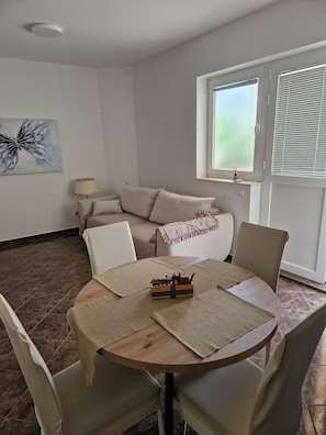 A dining area with a round table, chairs, and a decorative centerpiece.