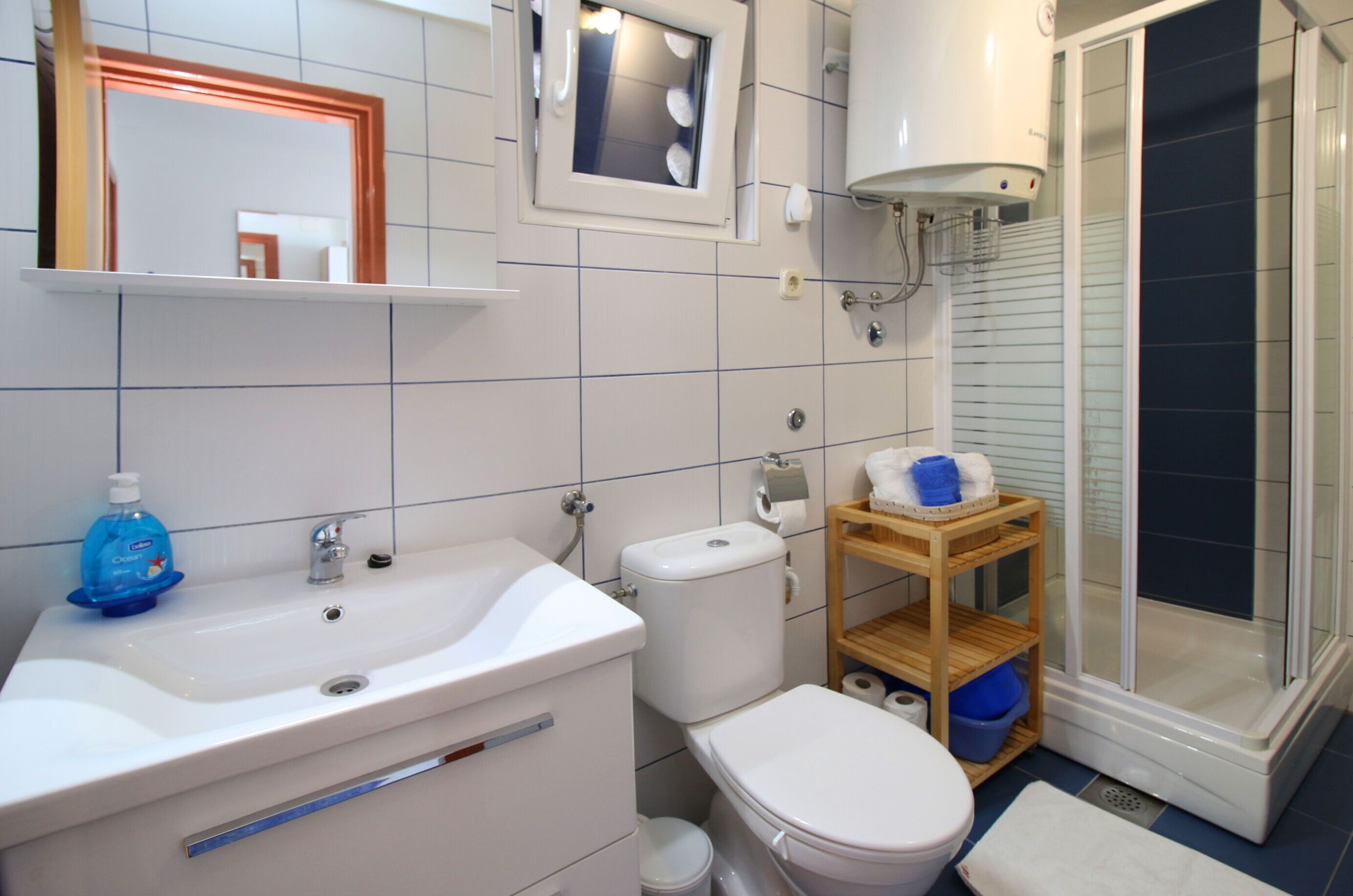 Een badkamer met een wastafel, toilet en douche.
