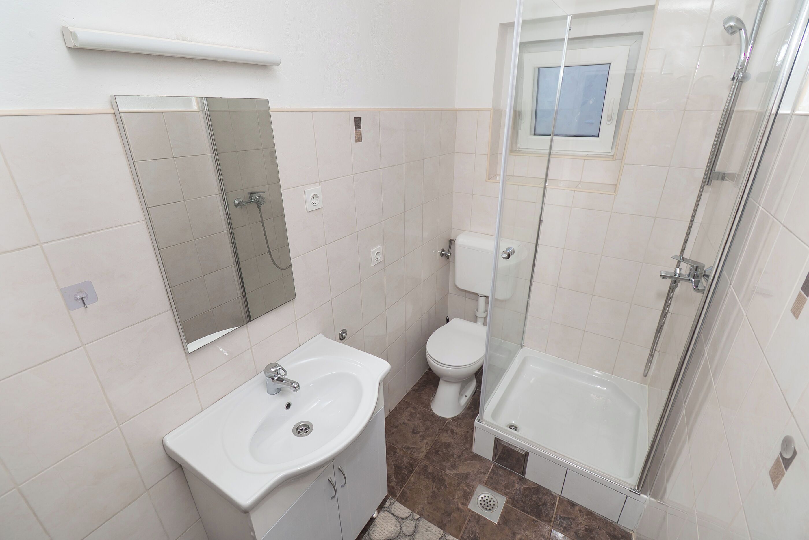Un baño con lavamanos, inodoro y ducha.