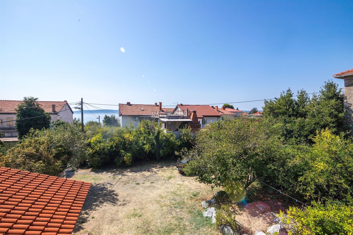 A residential area with houses, a clear sky, and a dirt path.