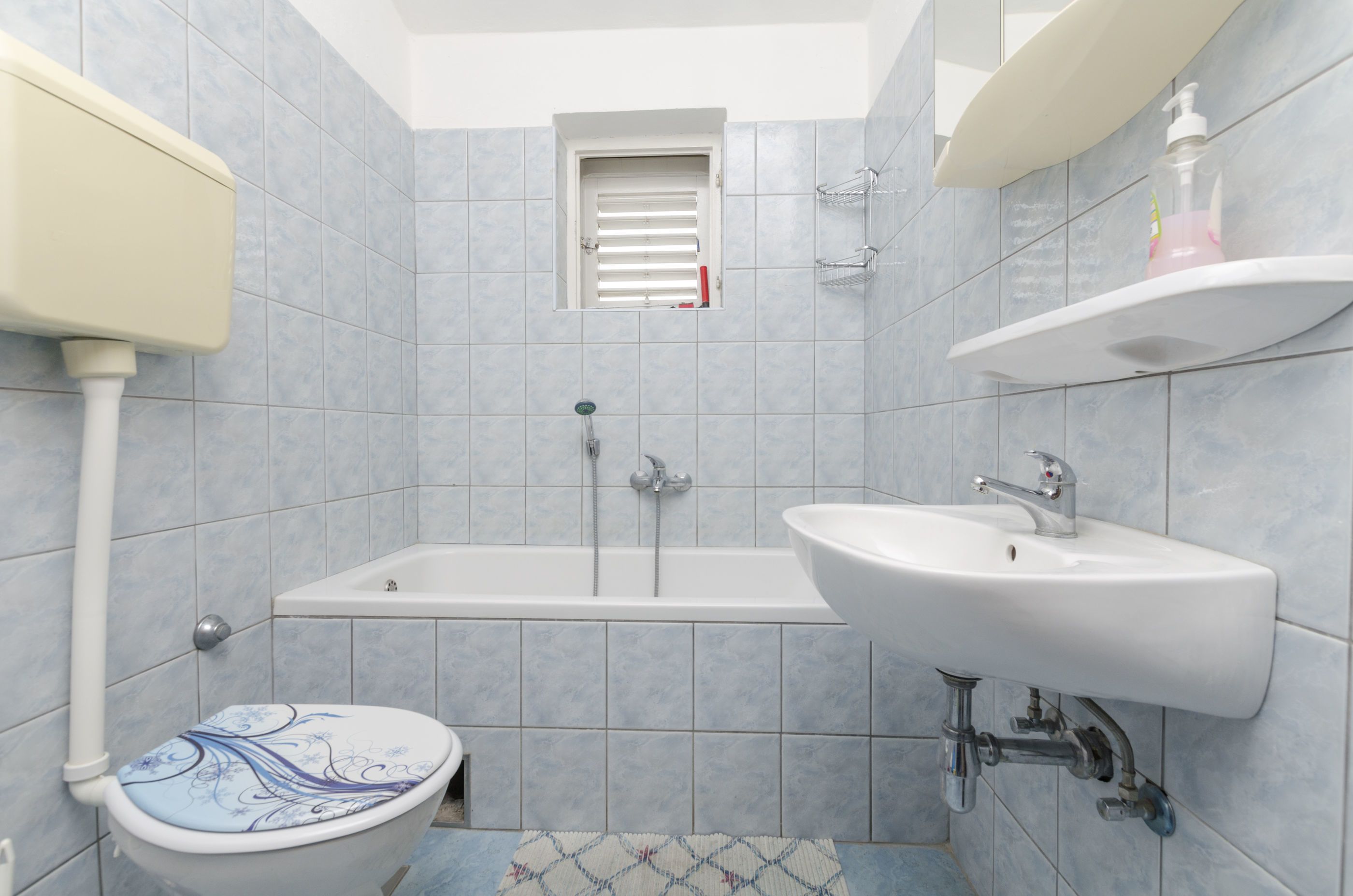 A bathroom with a toilet, bathtub, and sink.