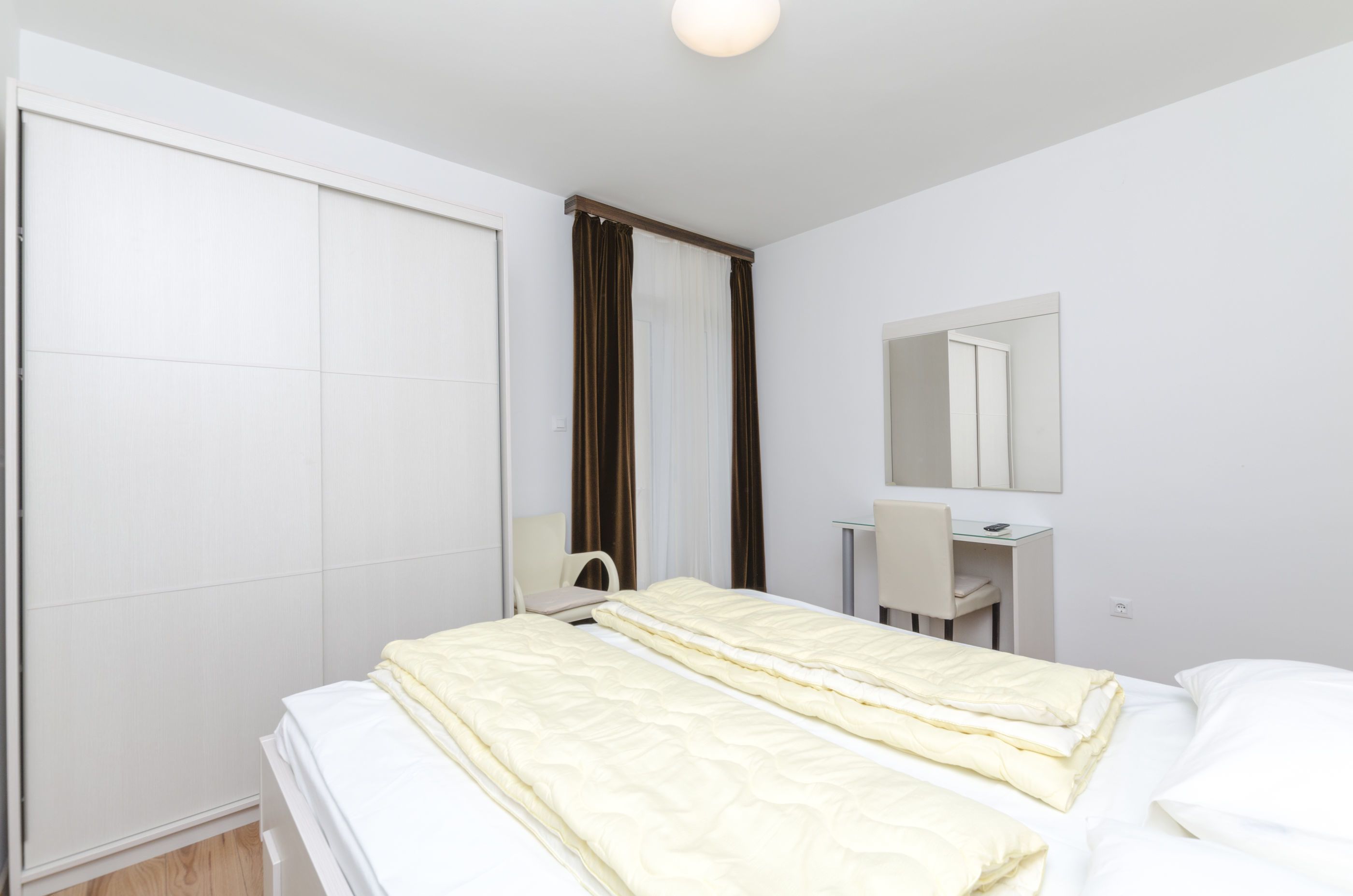Una habitación de hotel moderna con cama, escritorio y espejo.
