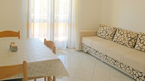 Una sala de estar con un sofá, una mesa y una silla.