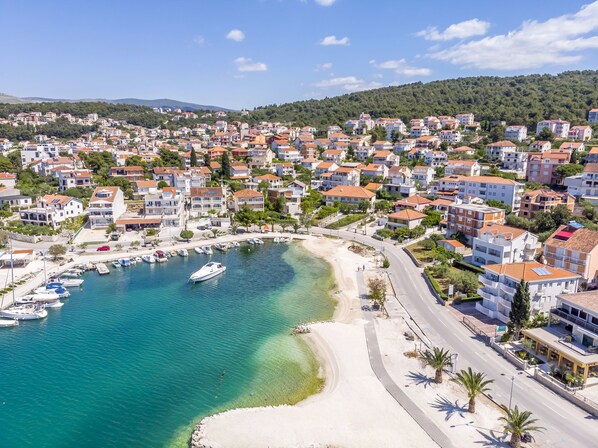 Uma cidade costeira com um porto, praia de areia e edifícios residenciais.