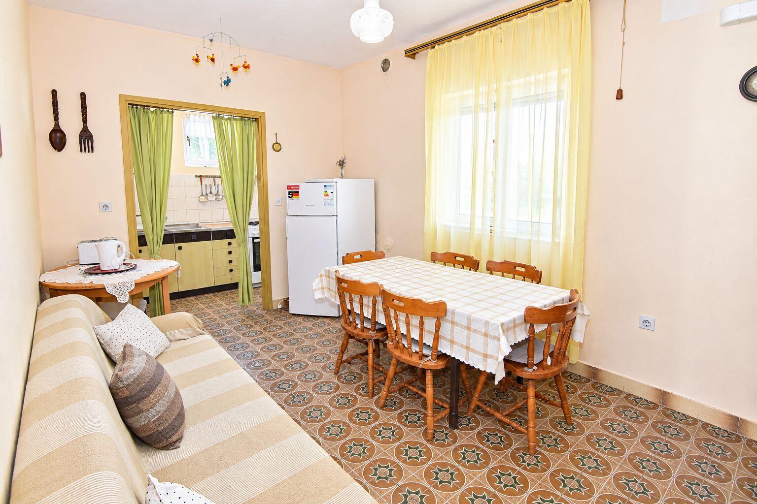 A compact living space with a dining area, kitchenette, and a sofa.