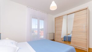 A bedroom with a bed, a wardrobe, and a window with curtains. - House Marija (Arbanija)