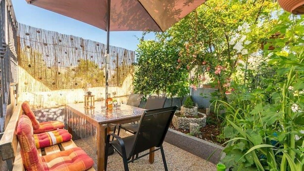 Un patio all'aperto con tavolo, sedie e una panca.