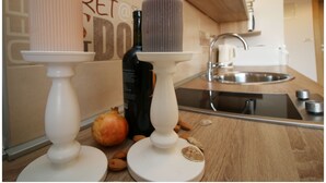 Une cuisine avec un plan de travail en bois, un évier blanc et une bouteille d’huile d’olive.