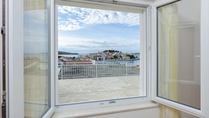 Ein Balkon mit Blick auf eine Küstenstadt und ein Gewässer.