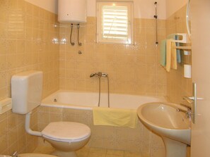 A bathroom with a toilet, bathtub, and sink.