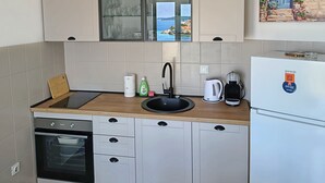 A modern kitchen with a built-in oven, a sink, and a refrigerator.