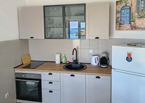 A modern kitchen with a built-in oven, a sink, and a refrigerator. - Apartment Nensi (Primosten)