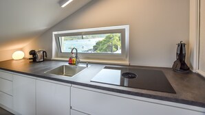 Een moderne keuken met een ingebouwde spoelbak, een raam met uitzicht op een waterpartij en een dakraam.