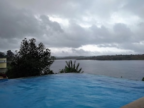 Piscina all'aperto, una piscina a sfioro, ombrelloni da piscina, lettini