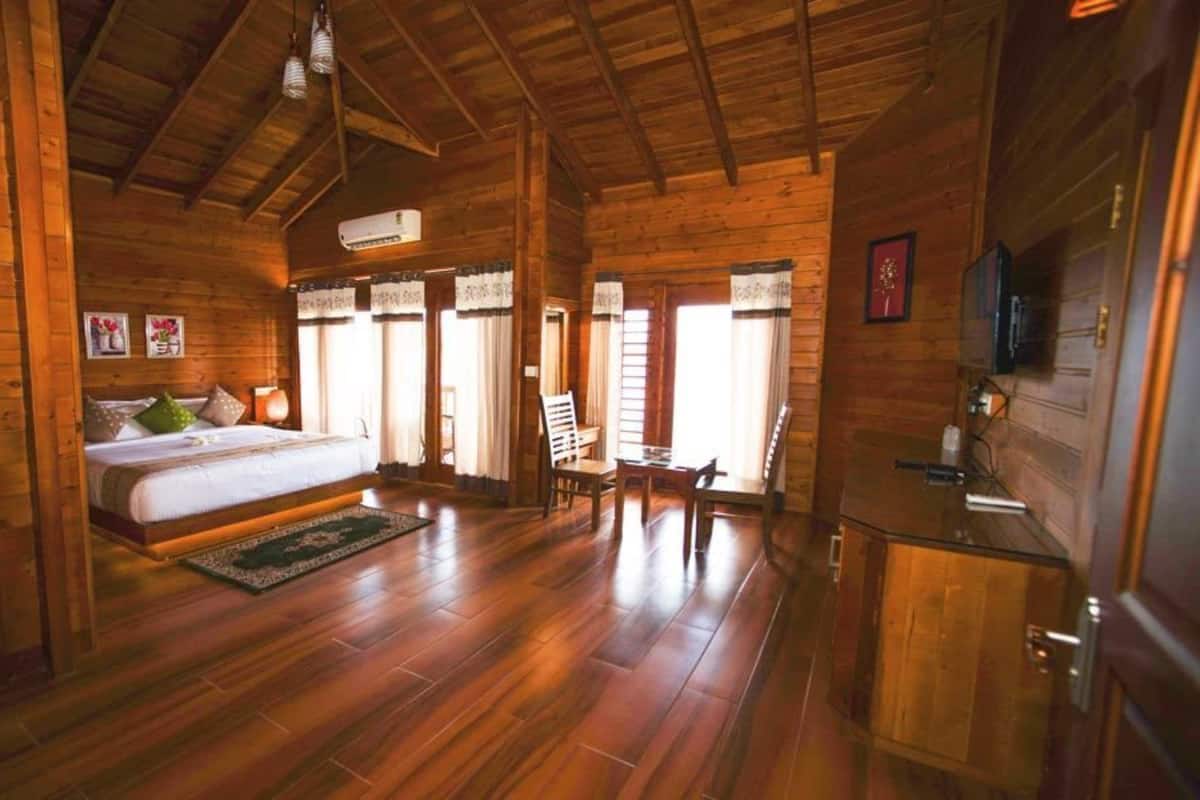 Una cabaña de madera con una cama grande, un comedor y una cocina.