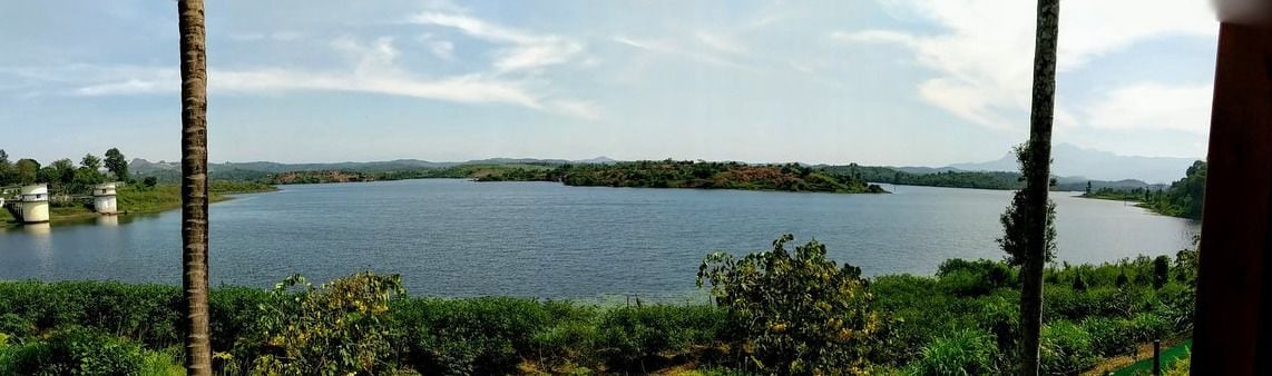Un lac entouré de verdure et de collines.