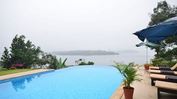 Outdoor pool, an infinity pool, pool umbrellas, pool loungers