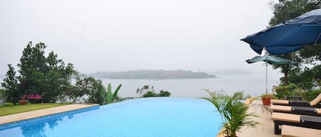 Outdoor pool, an infinity pool, open 9:00 AM to 8:00 PM, pool umbrellas