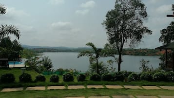 A lakeside view with a gazebo, a swimming pool, and a well-maintained garden.