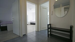 A bedroom with a bed, a bench, and a mirror. - Ferienwohnung  Bergisch Gladbach GL5 (Bergisch Gladbach)