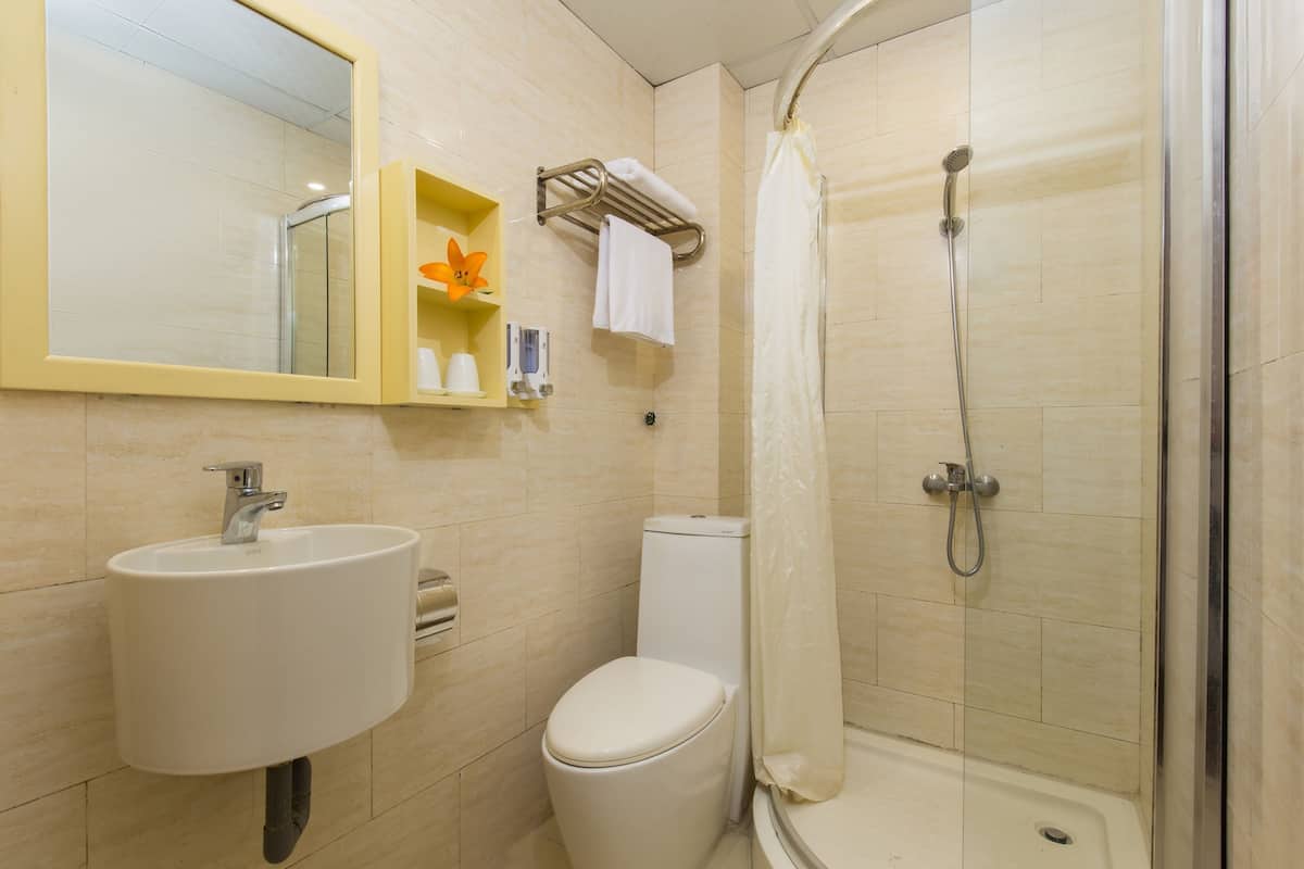 Un baño con lavamanos, inodoro y ducha.