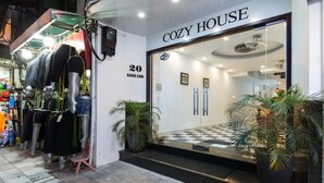A storefront with a sign reading "COZY HOUSE" and a number "20" indicating the unit number. - Hanoi Cozy House (Hanoi)