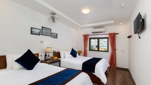 A hotel room with two beds, a TV, an air conditioner, and a window with curtains. - Hanoi Cozy House (Hanoi)