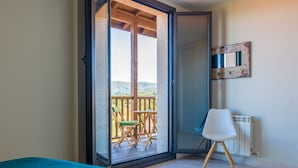 Una habitación con cama, una silla, una mesa y vistas a un balcón con mesa y sillas.