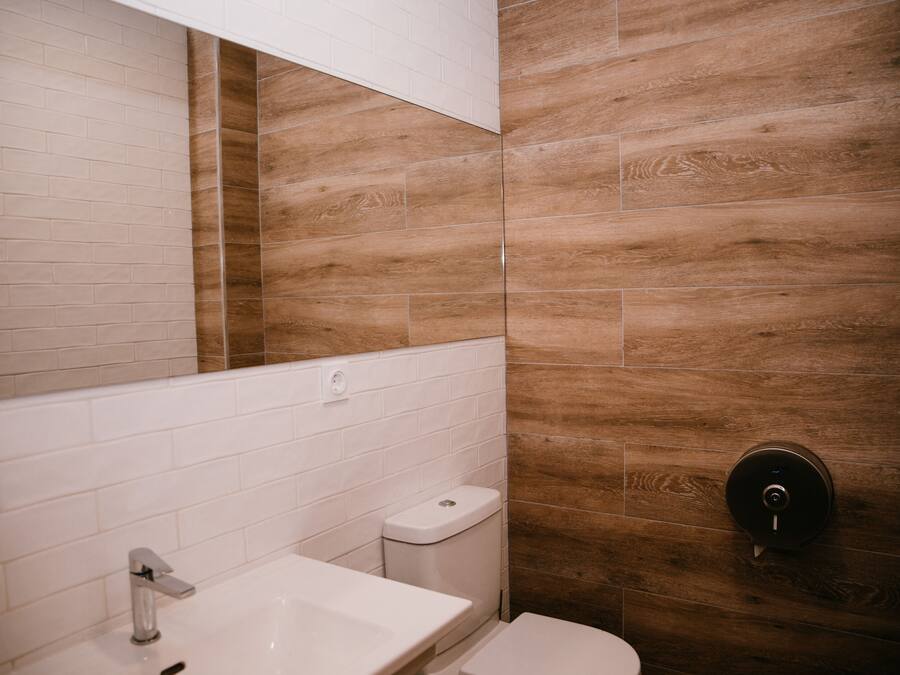 Une salle de bain avec un lavabo blanc, des toilettes et un miroir.