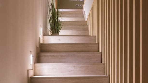 A wooden staircase with a sign reading "BIENVENIDOS" in a hallway.