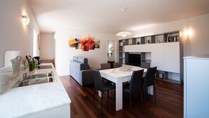 A modern kitchen with a dining area, white cabinetry, and a large painting on the wall. - House Vineyards Valpolicella, Garden Private Pool, 5 min. Verona, 20 min Garda (Fumane)