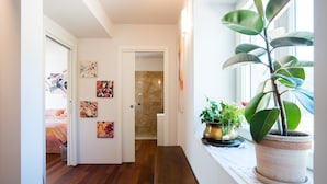 A hallway with wooden flooring, a bench, and a potted plant by a window. - House Vineyards Valpolicella, Garden Private Pool, 5 min. Verona, 20 min Garda (Fumane)