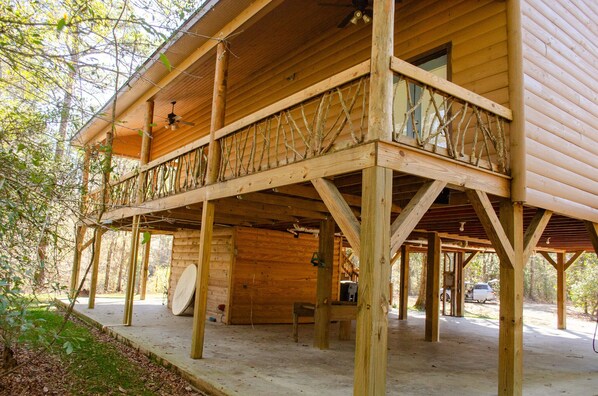 A wooden cabin with a balcony, a ceiling fan, and a bicycle in the background. - Family friendly cabin with an exclusive view of a waterfall on the Okatoma River (Seminary)